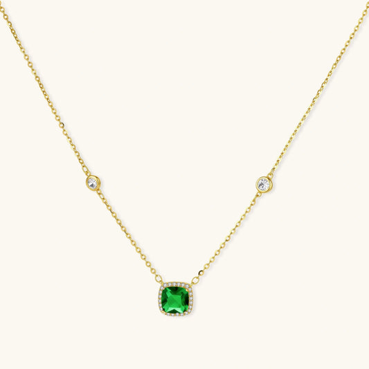 Delicate gold chain necklace featuring square emerald pendant with crystal halo and station accents