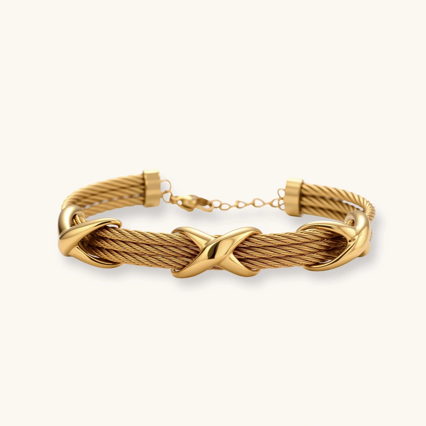 Gold-tone multi-strand twisted cable bracelet with polished X-cross knot accents and adjustable lobster clasp chain.